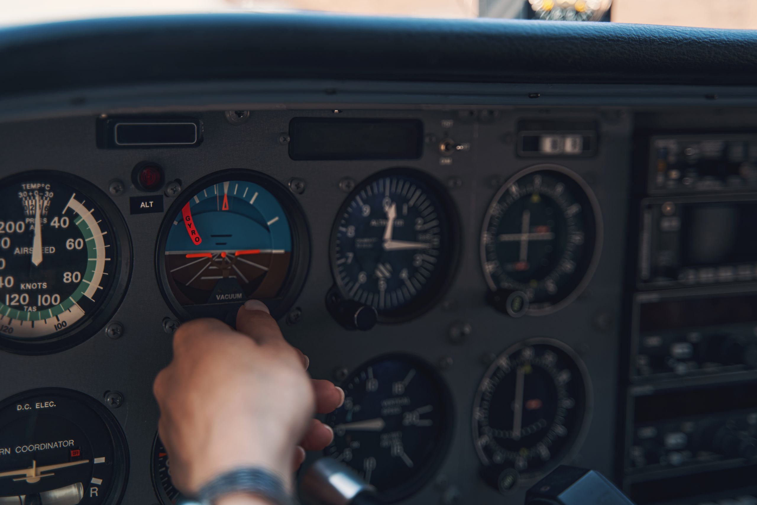 Piloto ajustando comandos no cockpit